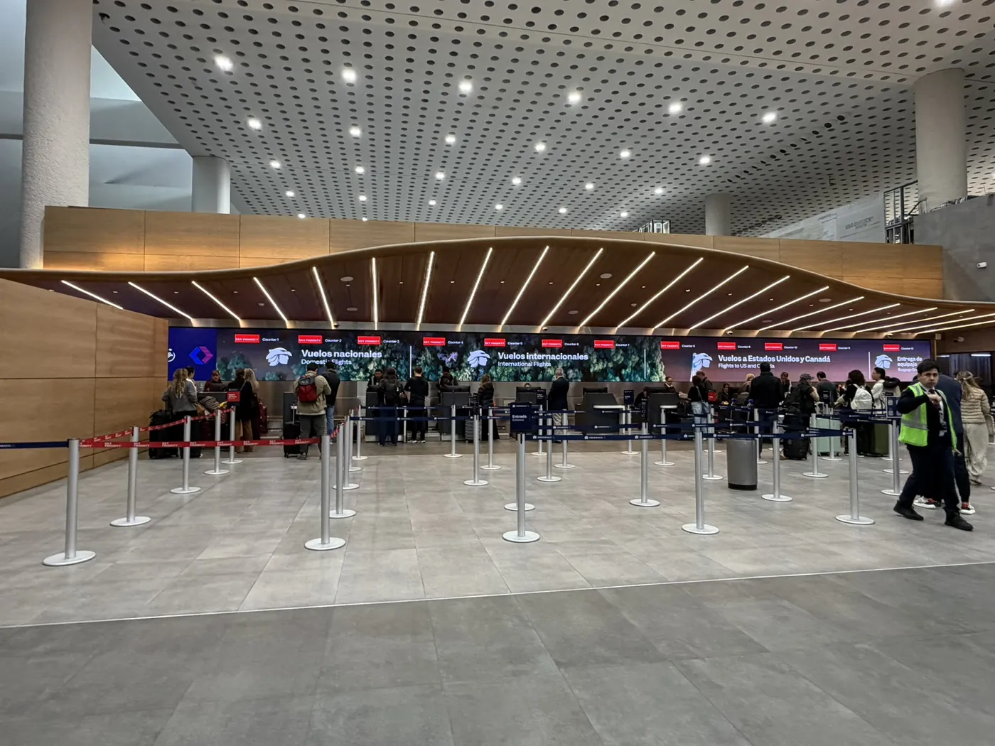 Mostradores de documentación de Aeroméxico en la Terminal 2 del aeropuerto de la Ciudad de México, con pantallas de vuelos nacionales, internacionales y a Estados Unidos y Canadá sobre las filas.