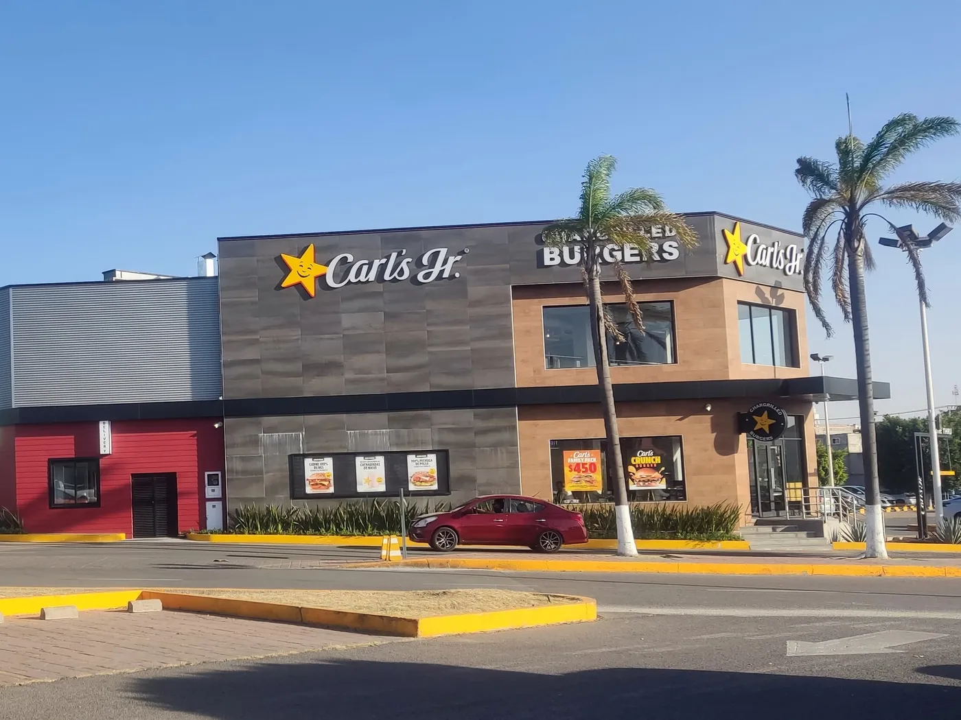 Restaurante de Carl's Jr. en el Tecámac Power Center, Estado de México, con la estrella sonriente sobre la fachada gris y el letrero Chargrilled Burgers en la esquina.