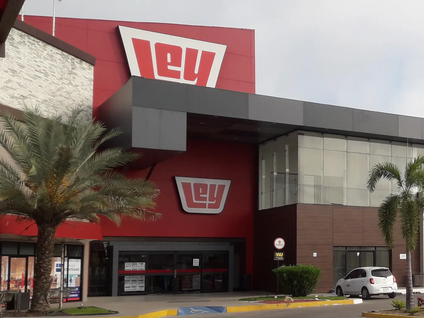Fachada de un supermercado Ley en Mazatlán, Sinaloa, con dos logos rojos de Ley sobre la entrada y palmeras al frente.