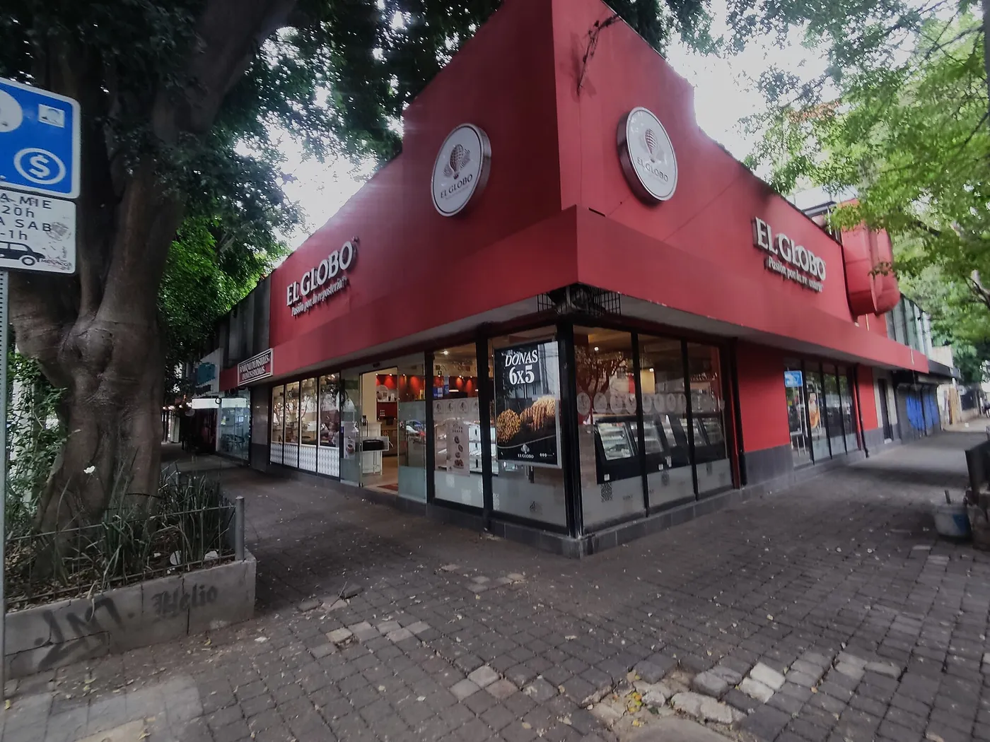 Esquina de una pastelería El Globo en la colonia Roma Norte, Ciudad de México, con su fachada roja y vitrinas.