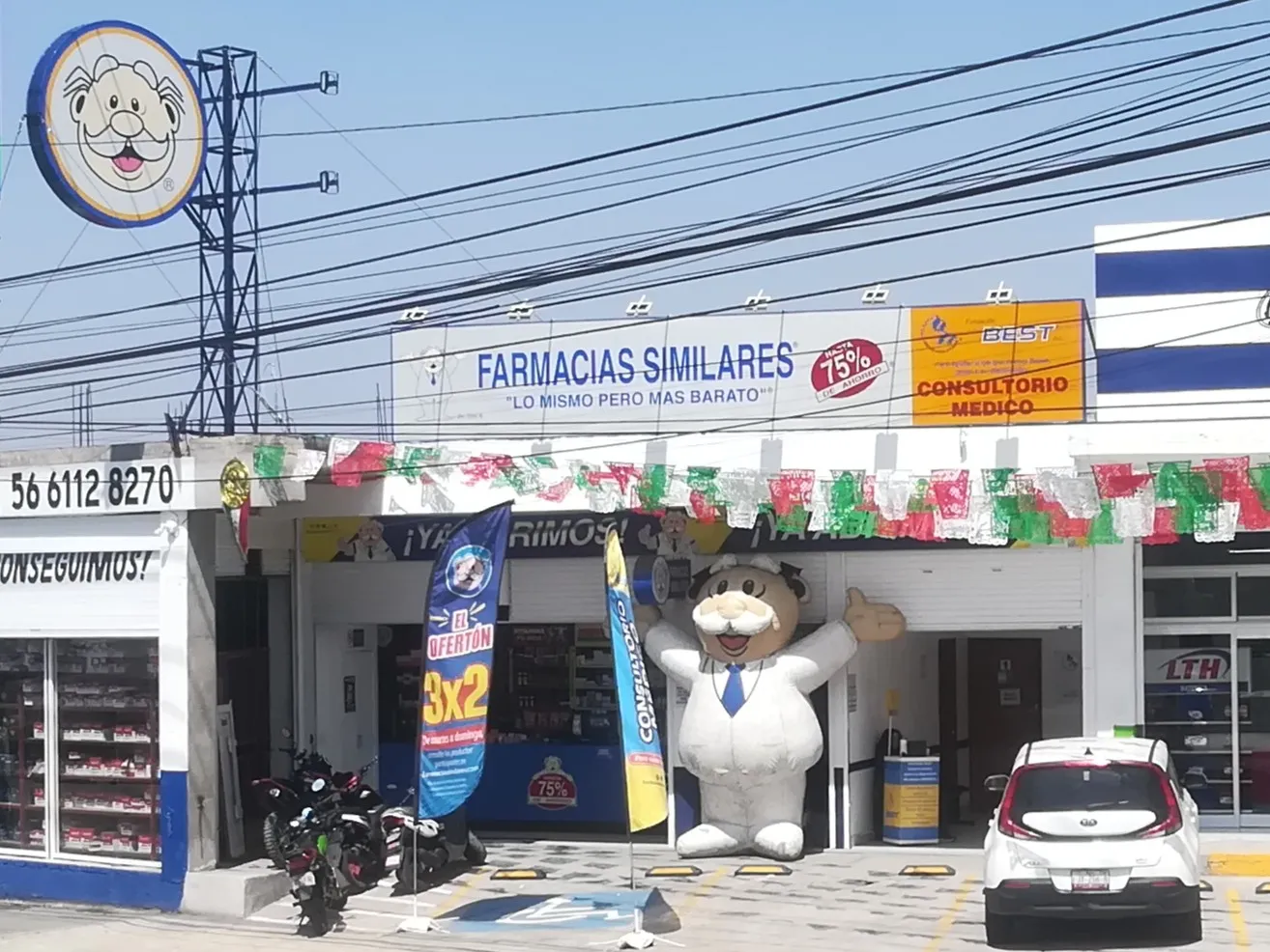 Farmacias Similares en la colonia Guadalupe Victoria de Ecatepec, Estado de México, con el Dr. Simi inflable en la entrada y, junto al letrero de la farmacia, el amarillo de «Consultorio Médico».