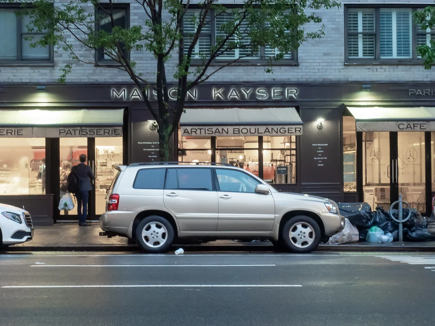 Fachada de Maison Kayser en el Upper East Side de Nueva York, con los letreros Boulangerie, Patisserie, Artisan Boulanger y Cafe sobre los aparadores.