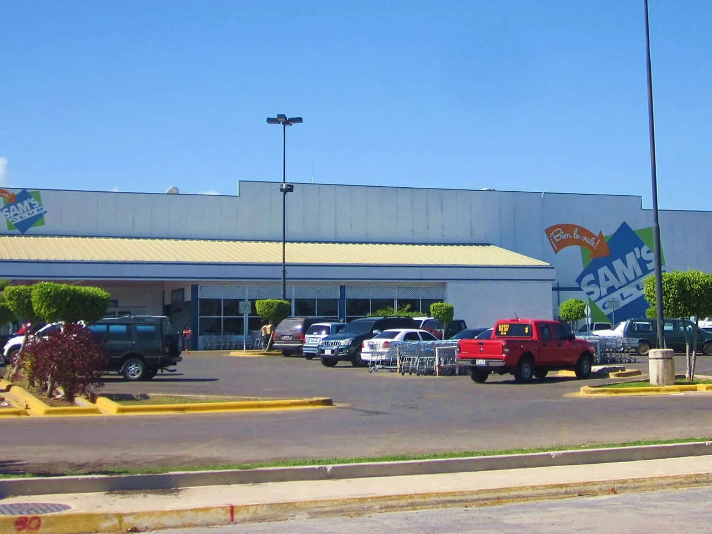 Fachada de Sam's Club en Chetumal, Quintana Roo, con el logotipo anterior de la marca y autos en el estacionamiento, en 2011.