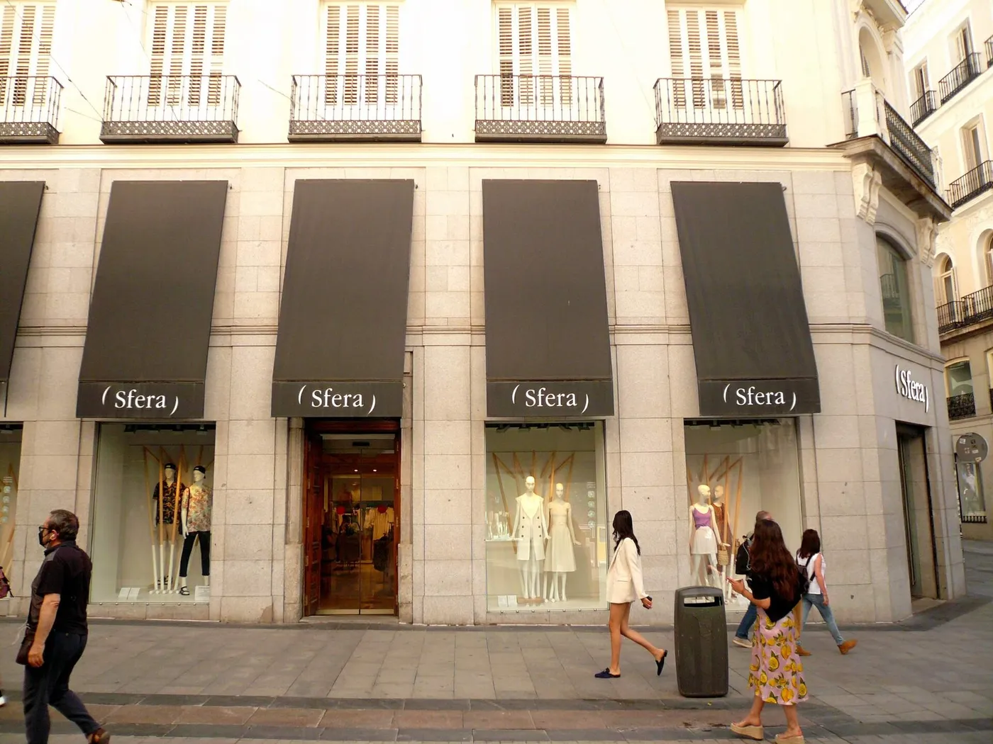 Tienda Sfera de la calle Preciados, en Madrid, con cuatro toldos negros con el logo de Sfera sobre los aparadores y la entrada.