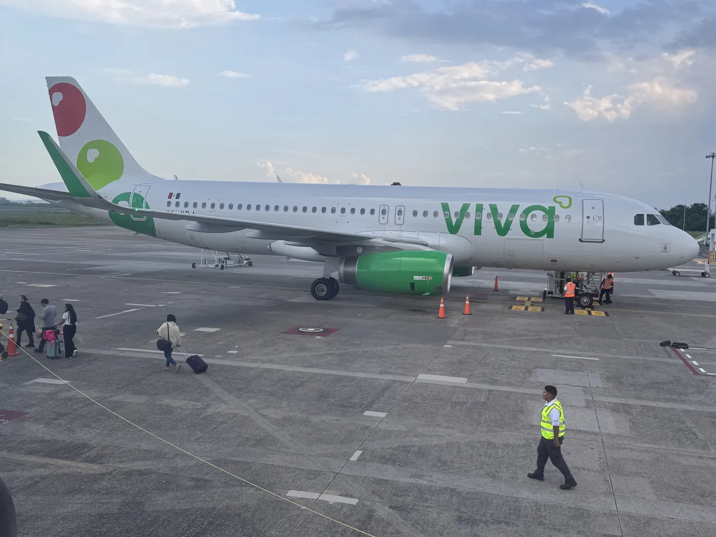 Airbus A320 de Viva Aerobus, con el logotipo verde en el fuselaje, en la plataforma del aeropuerto de Veracruz, con pasajeros caminando hacia el avión.