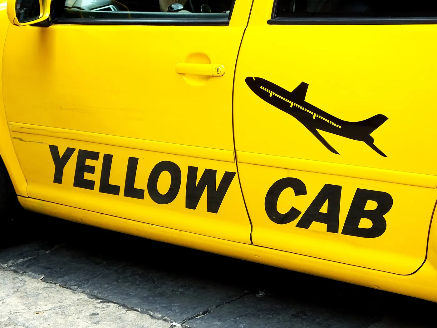 Puerta de un taxi amarillo de Yellow Cab con su logo del avión, en la Ciudad de México.